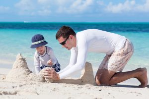 Mann und Kind am Strand statt Herrentag zuhause